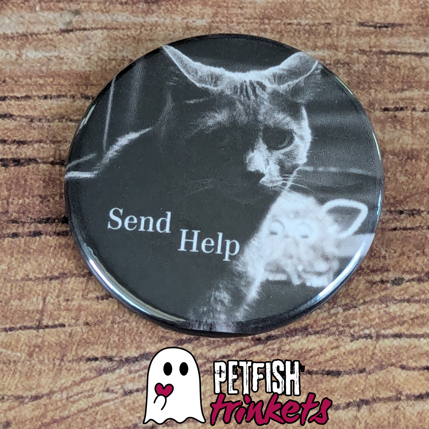 1.75in button with a cat looking annoyed in front of a furby