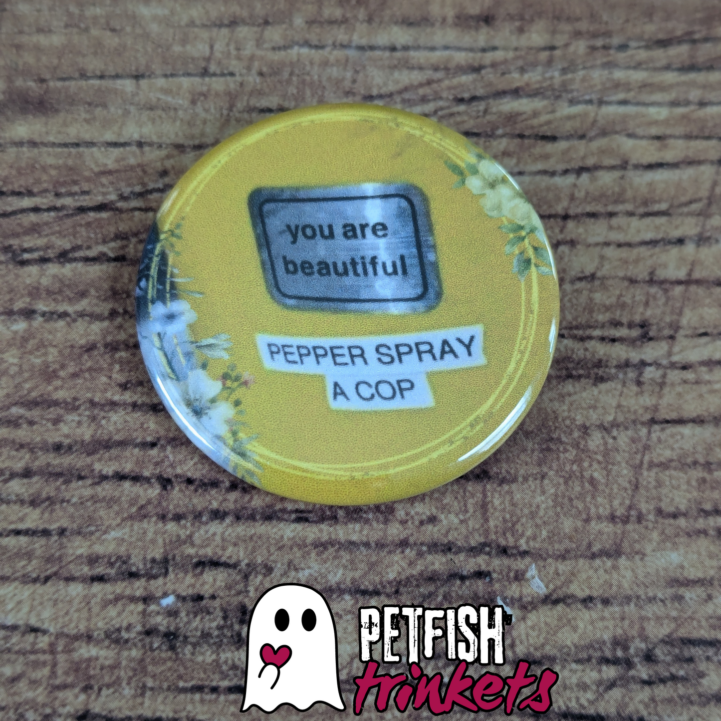 A 1.75in button that reads You Are Beautiful, Pepper Spray a Cop